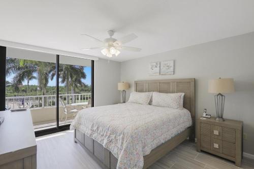 a bedroom with a bed and a large window at Ideal beachfront condo with pool and two balconies in Marco Island