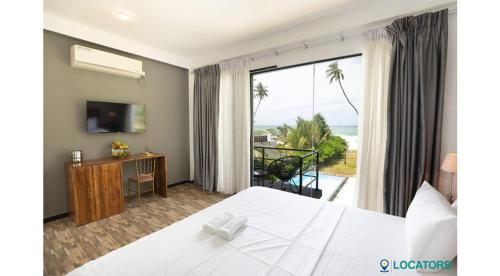 KalametiyaにあるEndlessblue Resort Kalametiyaのベッド付きのホテルルームで、海の景色を望めます。