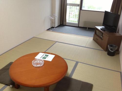 a room with a table and a tv on the floor at Granvillage Toya Daiwa Ryokan Annex in Lake Toya