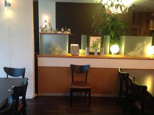 a bar with chairs in a restaurant with a chandelier at Granvillage Toya Daiwa Ryokan Annex in Lake Toya