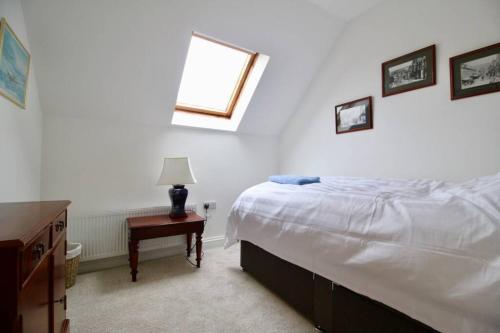 1 dormitorio con cama, mesa y ventana en Betern Place By Air Premier en Seaford