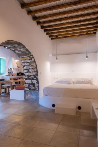 a bedroom with a bed and a stone wall at Psarona Hospitality in Cherronisos