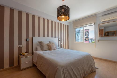ein Schlafzimmer mit einem großen Bett und einem Fenster in der Unterkunft Apartamento de 3 habitaciones en el barrio de las Artes, Soho in Málaga