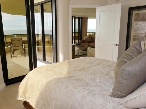 a bedroom with a bed and a view of the ocean at Sandcastle I-101 in Marco Island
