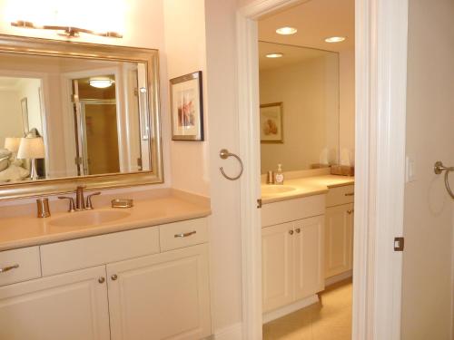 a bathroom with two sinks and a large mirror at Sandcastle I-101 in Marco Island