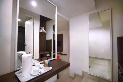 a bathroom with a sink and a mirror at favehotel PGC Cililitan in Jakarta