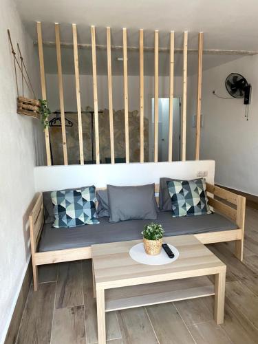 a wooden bench sitting in a room with pillows at Estudios Eucalyptal El Palmar a 100 m del mar in El Palmar