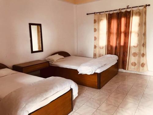 索拉哈的住宿－Hotel Gainda Island Camp，一间卧室设有两张单人床和一面镜子