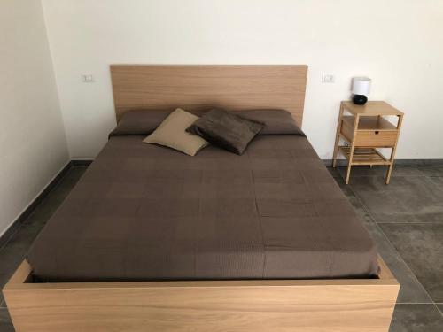 1 cama grande con cabecero de madera en un dormitorio en Verde Matematico en Vico del Gargano