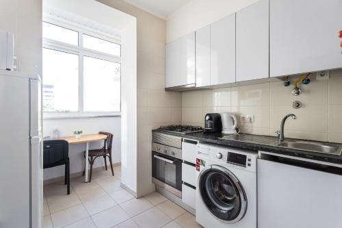 a kitchen with a washing machine and a sink at Lisboa Sweet Family Homestay in Lisbon