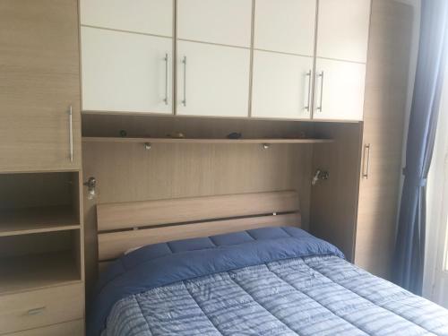 - une chambre avec un lit et des armoires blanches dans l'établissement Appartement terrasse dans palace Belle Epoque, à Menton