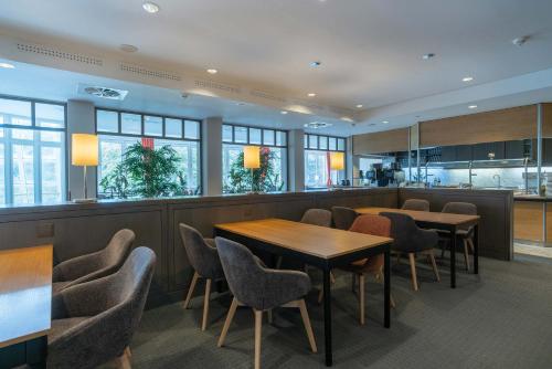 a restaurant with tables and chairs and a bar at Seminaris Hotel Bad Honnef in Bad Honnef am Rhein