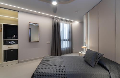 a bedroom with a large bed and a mirror at Hotel Perla del Sur in Torremolinos