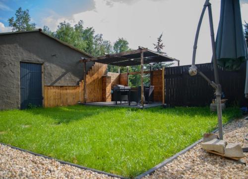a backyard with a gazebo and green grass at Apart Oderblick in Neubleyen