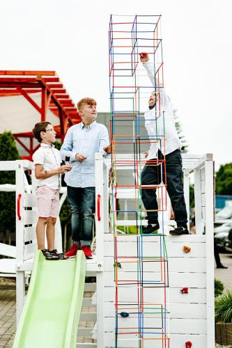 three people standing on a ladder on a slide at Romeo&Julia in Toruń
