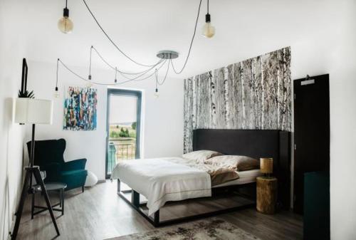 a bedroom with a bed and a chair at Joy Aparthotel Keilberg in Klínovec