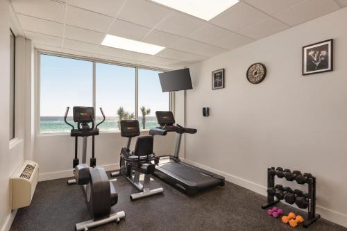 a gym with three exercise bikes in a room with a window at Radisson Beachfront Hotel - Panama City Beach in Panama City Beach
