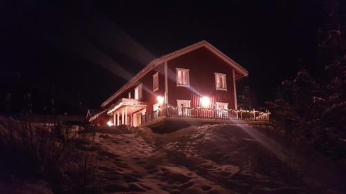 a house with lights on the side of it at night at Backamgården in Sälen
