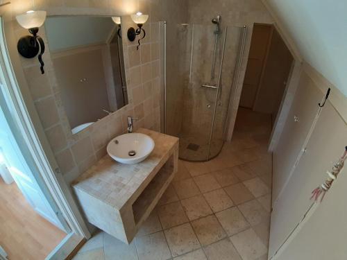 a bathroom with a sink and a shower at Det Gule Huset Hurdal in Hurdal