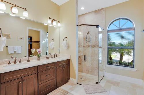 un baño con ducha y lavabo en Waterfront home with pool, spa and outdoor kitchen, en Marco Island