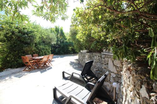 eine Gruppe von Stühlen neben einer Steinmauer in der Unterkunft Makarska city center1 willa in Makarska