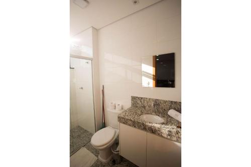 a bathroom with a toilet and a sink at Lockings Lourdes 4 in Belo Horizonte