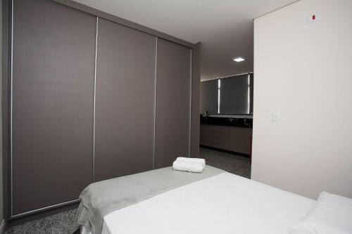 een slaapkamer met een wit bed en een grote muur bij LK Lourdes 8 in Belo Horizonte