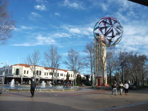 a group of people walking around a plaza with a large sphere at Valdez Motor Lodge in Hastings