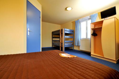 a bedroom with a large bed and a television at Hôtel & Résidence Avermes in Avermes