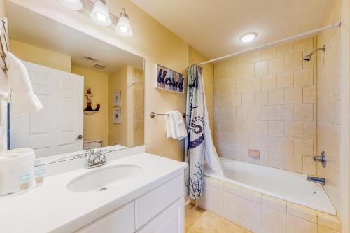 uma casa de banho com um lavatório, uma banheira e um chuveiro em Summerhouse 402 em Mexico Beach