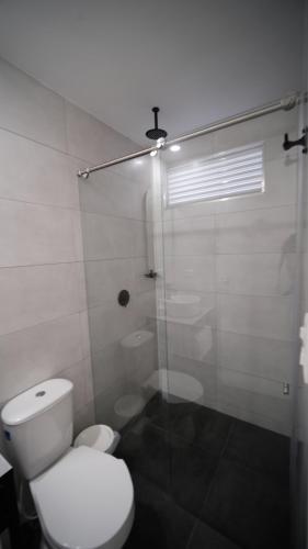 a bathroom with a toilet and a glass shower at Hotel San Telmo in Buga