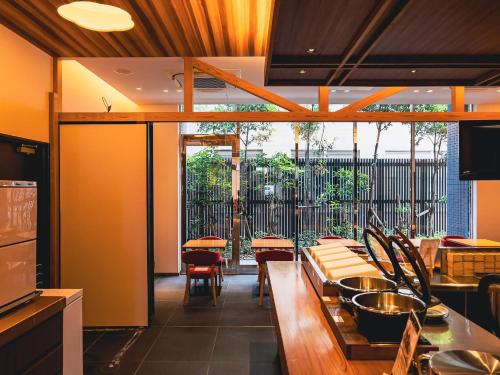 a restaurant with tables and chairs and a large window at APA Hotel Sugamo Ekimae in Tokyo
