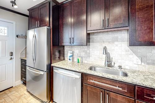 a kitchen with wooden cabinets and a stainless steel refrigerator at Sea Palms in Fort Walton Beach