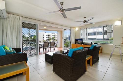 a living room with chairs and a couch and a balcony at The Beach Houses Maroochydore in Maroochydore