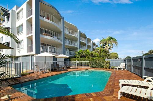 a swimming pool in front of a apartment building at The Beach Houses Maroochydore in Maroochydore