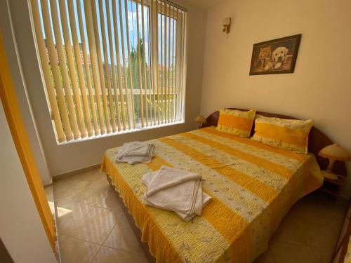 a bedroom with a bed with towels on it at Studios in Complex Colosseum in Kranevo