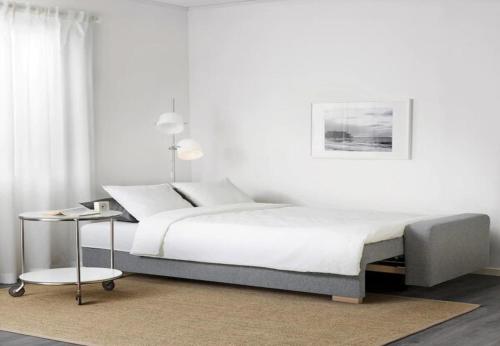 ベニドルムにあるApartment Mirador de NovaCalaの白いベッドルーム(ベッド1台、テーブル付)