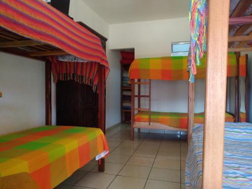 a bedroom with two bunk beds with colorful sheets at Cachoeiras Pé da Serra in São João Batista do Glória