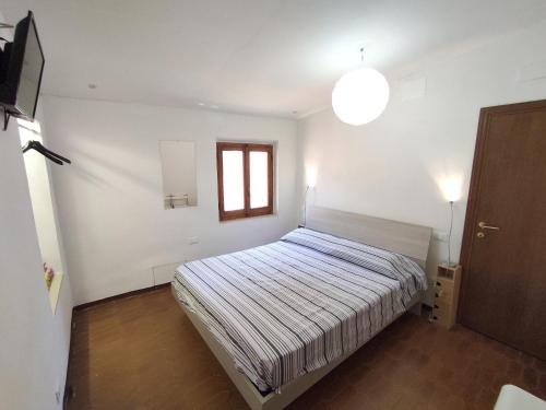 a small bedroom with a bed and a window at Casa via della Rocca Luna in Poggibonsi