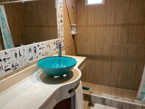 a bathroom with a blue bowl sink on a counter at Los Carolinos by DOT Cabana in Tafí del Valle