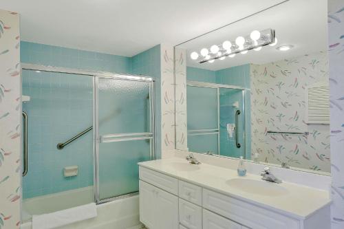 a bathroom with a shower and a sink and a mirror at Cozy beachfront condo with pool and tennis courts in Marco Island