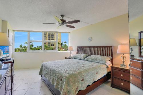 a bedroom with a bed and a ceiling fan at Cozy beachfront condo with pool and tennis courts in Marco Island