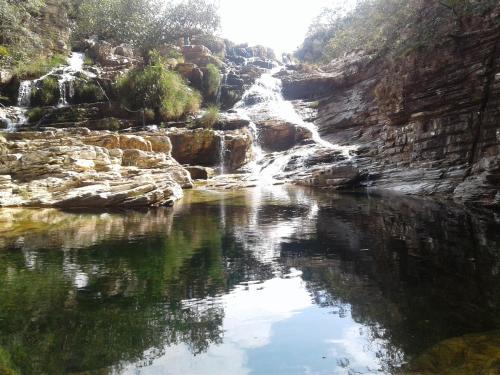 a waterfall and a pool of water in a river at Cachoeiras Pé da Serra in São João Batista do Glória