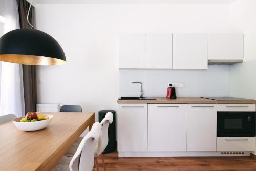 eine Küche mit einem Holztisch und einer Obstschale in der Unterkunft Galeria Apartments - Jasná in Demänovská Dolina