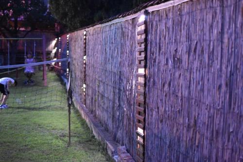 a fence with a person playing tennis on a court at Konak Garavi sokak in Kuršumlija