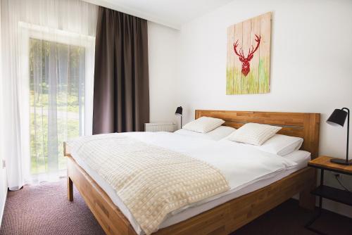 a bedroom with a large bed and a window at Galeria Apartments - Jasná in Demanovska Dolina