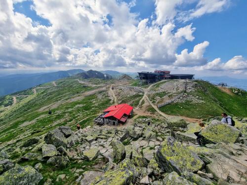a small red house on top of a mountain at Galeria Apartments - Jasná in Demanovska Dolina
