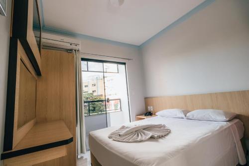 a bedroom with a bed with a towel on it at Hotel Triângulo in Caldas Novas