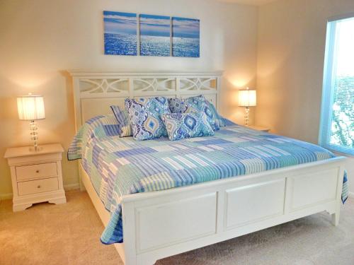 białe łóżko z niebieskimi poduszkami w sypialni w obiekcie Estuary II 2071 w mieście Marco Island