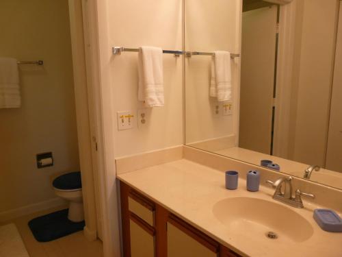 W łazience znajduje się umywalka, lustro i toaleta. w obiekcie Estuary II 2071 w mieście Marco Island